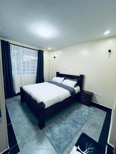 ein Schlafzimmer mit einem großen Bett und einem Fenster in der Unterkunft Idyllic Sojourn in Nakuru