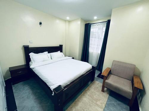 ein Schlafzimmer mit einem Bett, einem Stuhl und einem Fenster in der Unterkunft Idyllic Sojourn in Nakuru