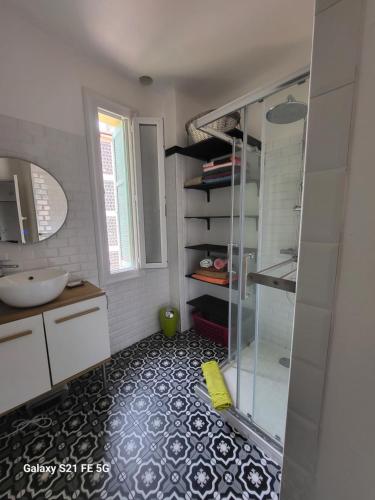 une salle de bain avec une douche en verre et un lavabo dans l'établissement T3 Ajaccio vue mer, à Ajaccio