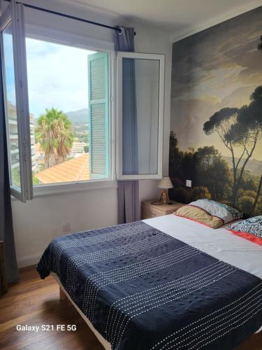 une chambre avec un lit avec une grande fenêtre dans l'établissement T3 Ajaccio vue mer, à Ajaccio