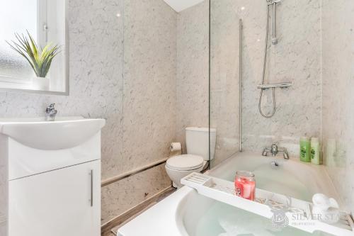 ein Badezimmer mit einer Badewanne, einem WC und einem Waschbecken in der Unterkunft Silver Stag Properties, Newly Renovated 2 BR House in Church Gresley