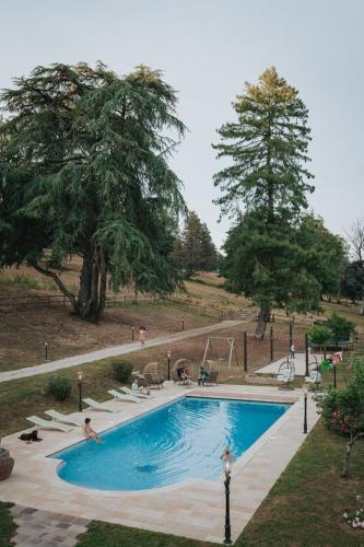 - une piscine dans un parc avec des personnes assises autour dans l'établissement Domaine des Chailloux, à Jully-lès-Buxy