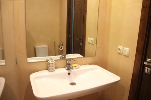 W łazience znajduje się biała umywalka i lustro. w obiekcie New Fez Apartments w Fezie