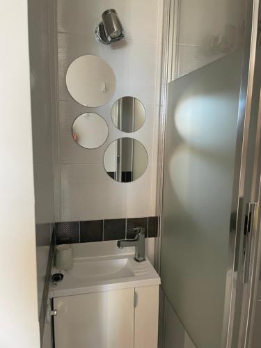 a bathroom with three mirrors on the wall above a toilet at SGDB in Sainte-Geneviève-des-Bois