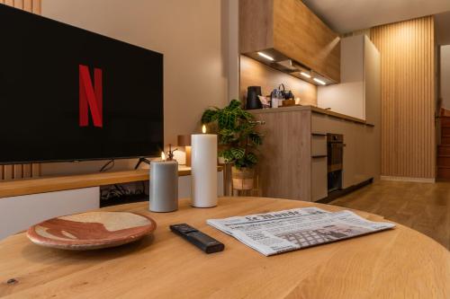 - une table avec une télévision et un journal dans l'établissement Host Inn - Duplex Insolite & Chic - Ancienne librairie, à Lyon