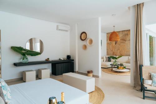 a white living room with a bed and a mirror at Ycona Eco-Luxury Resort, Zanzibar in Dikoni