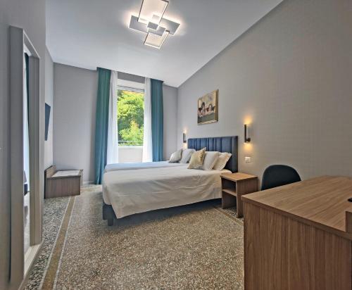 a bedroom with a bed and a desk and a window at Vatican museum guest house in Rome