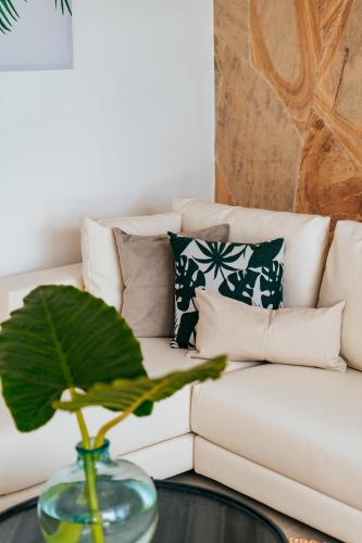 a living room with a white couch with pillows at Ycona Eco-Luxury Resort, Zanzibar in Dikoni