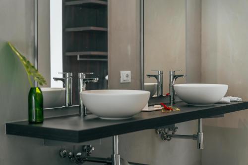 a bathroom with two white bowls on a counter at Ycona Eco-Luxury Resort, Zanzibar in Dikoni