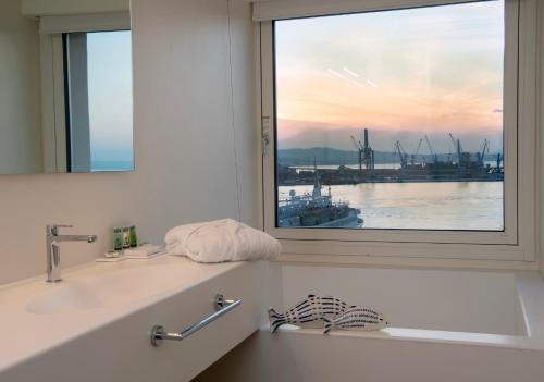 a bathroom with a window with a view of a harbor at Grand Hotel Palace in Ancona