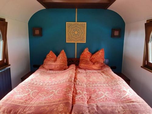 a bed with orange pillows in a room at Zigappo Orientale in Lychen