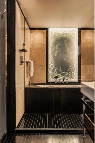 a bathroom with a tub and a window at Bvlgari Hotel Paris in Paris