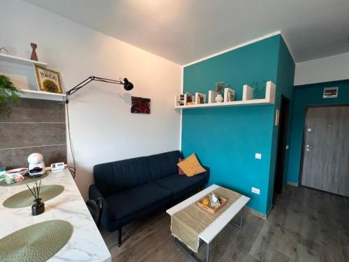 een woonkamer met een blauwe bank en een tafel bij Coroama'S House in Iaşi