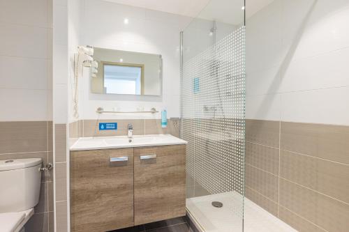 a bathroom with a toilet and a sink and a shower at Les Loges du Park in Aix-les-Bains