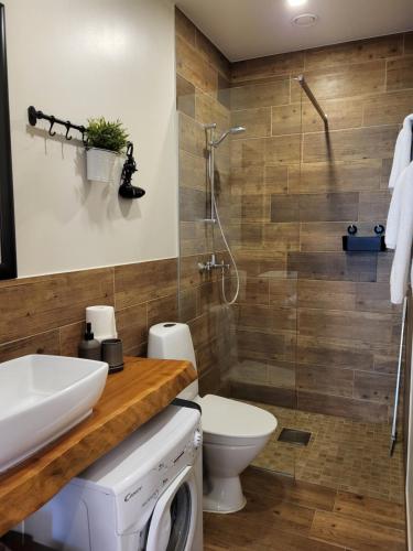 a bathroom with a shower and a toilet and a sink at Kuressaare Family and Garden Apartments in Kuressaare