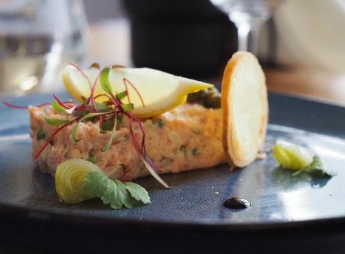 a plate with a piece of food with a slice of lemon at Centrum Konferencyjno-Apartamentowe Mrówka in Warsaw