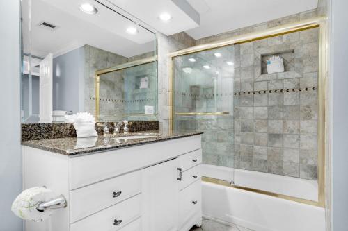 baño blanco con ducha y lavamanos en Surfside Resort #309, en Destin