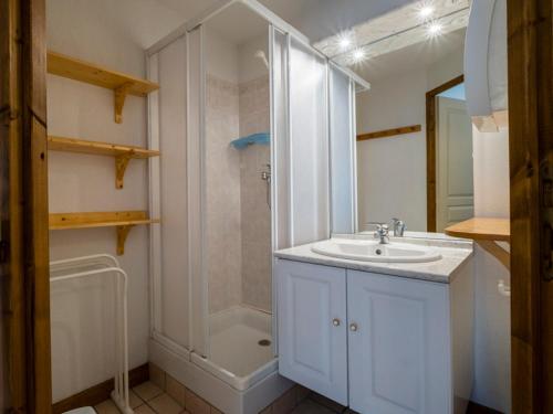 een witte badkamer met een douche en een wastafel bij Appartement aux portes de Megeve in Praz-sur-Arly