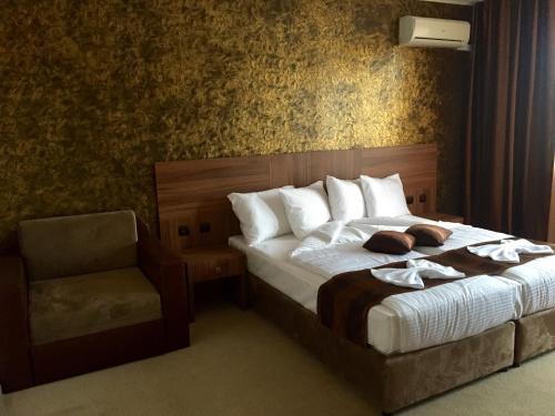 a hotel room with a bed and a chair at Family Hotel Kontesa in Lozenets