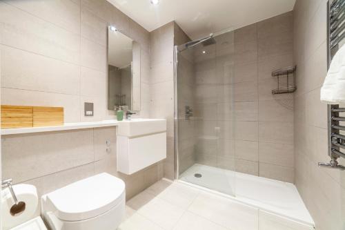 a bathroom with a toilet and a sink and a shower at Spacious Modern 3 BR Apt w Balcony, Woolwich in Woolwich
