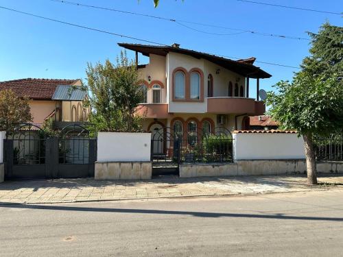 a house with a fence in front of a street at Славина къща in Perushtitsa