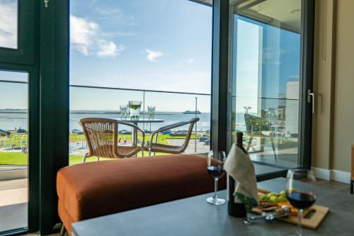 a room with a view of the ocean and a table at Shoreline Apartments in Galway