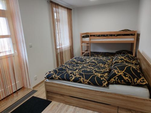 a bedroom with a bunk bed with a black and gold blanket at Horský apartmán Hubertus č.19 in Karlova Studánka