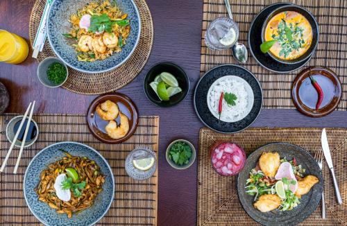 a wooden table with plates of food on it at Mala Garden Design Hotel in Siófok