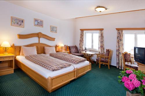 a hotel room with a bed and a television at Hotel guter Hirte in Huttwil