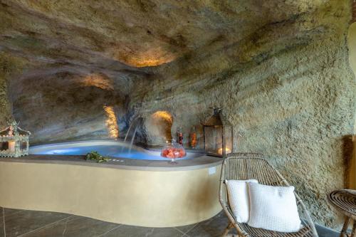 ein Badezimmer mit einer Badewanne in einer Steinmauer in der Unterkunft Il Conte, Traditional Tuscany 3 bedrooms Luxury Farmhouse Villa with Private Pool and SPA in Orentano in Orentano