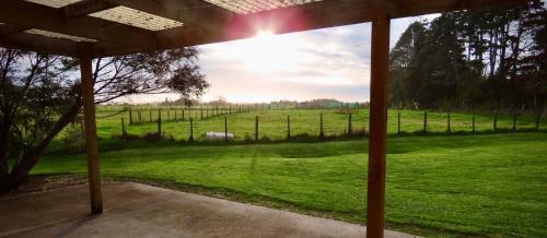 uma vista para um campo a partir de um alpendre coberto em The Barn em Westport