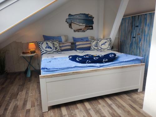 1 dormitorio con 1 cama con sábanas y almohadas azules en Gästehaus Zur Seemöwe, Fewo 1 "Seeblick", en Dahme