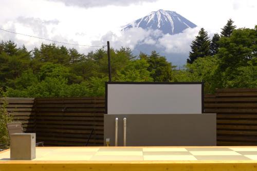 a white billboard in front of a snow covered mountain at dots by Dot Glamping Suite 001 in Fujikawaguchiko