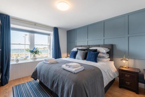 a bedroom with a large bed with towels on it at Shorefront Apartment - Sea View with 3 Bedrooms in Anstruther