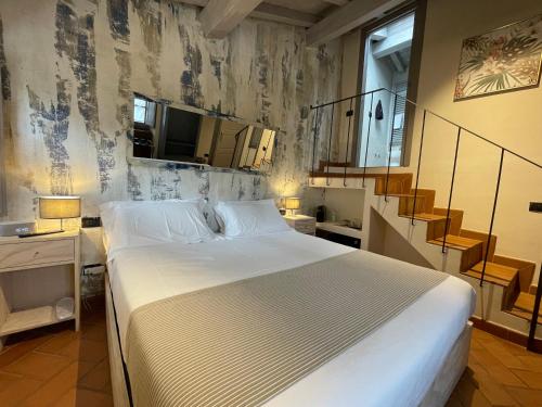 a bedroom with a large bed and a staircase at Dimora Carducci in Pietrasanta