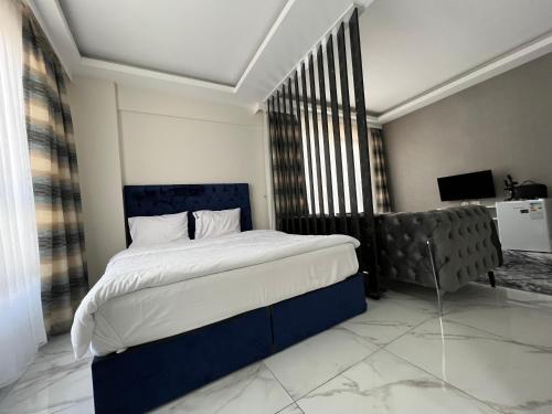 a bedroom with a blue bed and a couch at Tower352 in Melikgazi