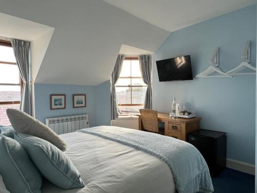 a bedroom with a bed and a desk and a window at Fort Charlotte Guest House in Lerwick