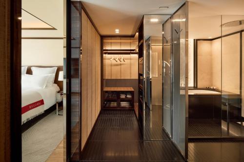 a bathroom with a shower and a bed in a room at Bvlgari Hotel Paris in Paris
