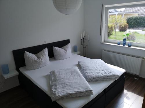 ハーヘンブルクにあるFerienwohnung Am Philosophenwegのベッドルーム1室(白いシーツ付きのベッド1台、窓付)