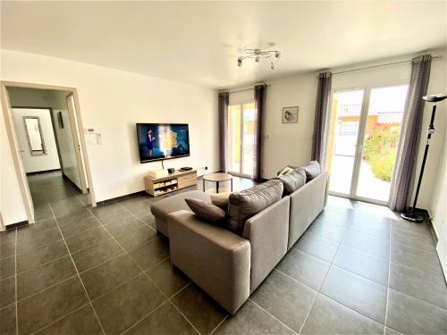 salon z kanapą i telewizorem z płaskim ekranem w obiekcie GITE CESAR 6p, 3ch, piscine privée, terrain privé clos, terrain de pétanque w mieście Vallon-Pont-dʼArc