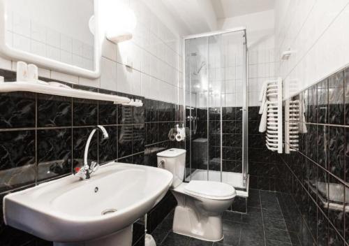 a black and white bathroom with a toilet and a sink at Hotel Helios 300m od Krupówek nowy BASEN od 12 lipca in Zakopane
