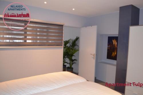 a bedroom with a bed and a window with a blind at Relaxed Apartments Haarlem in Haarlem