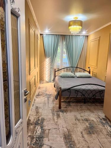 ein Schlafzimmer mit einem Bett mit blauen Vorhängen und einem Fenster in der Unterkunft 2-х комнатная квартира на Арбате in Almaty