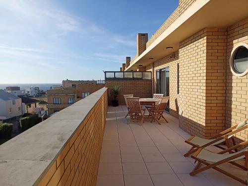 einen Balkon mit einem Tisch und Stühlen auf einem Gebäude in der Unterkunft Sunset Lounge CorgoMar in Lavra
