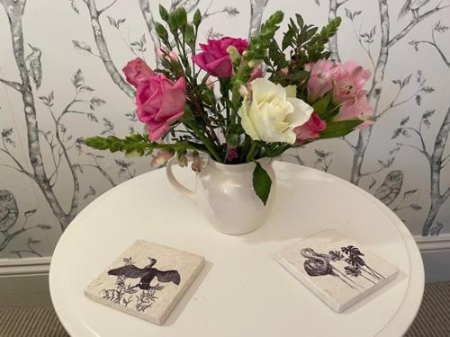 a vase of flowers on a table with two cards at The Mount Somerton Retreat - Nr Bruton, Glastonbury, The spectacular Wells Cathedral, Millfield School, Leonardo Helicopters, Yeovilton in Somerton
