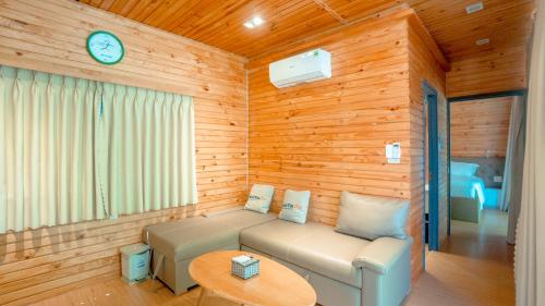 a living room with a couch and a clock on the wall at An Hoa Residence in Long Hai