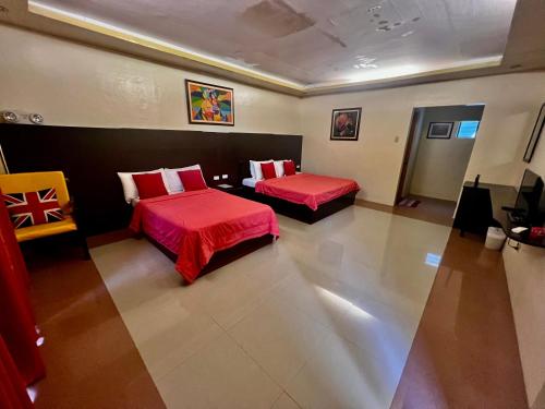 a hotel room with two beds and a chair at Hotel Casa Teofista in Panglao