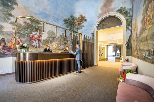 a man standing at a bar in a room with a painting at Hotel La Scaletta al Ponte Vecchio in Florence