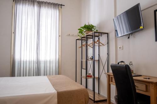een slaapkamer met een bed, een bureau en een televisie bij Ai Vicerè in Palermo