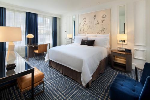 サンディエゴにあるジ US グラント ア ラグジュアリー コレクション ホテル サンディエゴの大きなベッドとデスクが備わるホテルルームです。